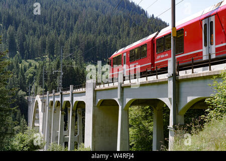 Langwies, GR / Switzerland - 24. July, 2015: the Rhaetian railway crosses the Langwies Viaduct over a deep canyon on the Chur - Arosa line Stock Photo