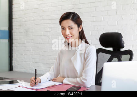 Woman doing office work, Beijing, China Stock Photo