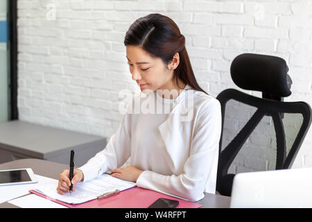 Woman doing office work, Beijing, China Stock Photo