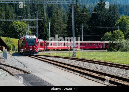 Langwies, GR / Switzerland - 24. July, 2015: the Rhaetian railway arrives at the small idyllic Langwies train station on the Chur - Arosa line Stock Photo