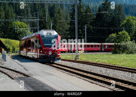 Langwies, GR / Switzerland - 24. July, 2015: the Rhaetian railway arrives at the small idyllic Langwies train station on the Chur - Arosa line Stock Photo