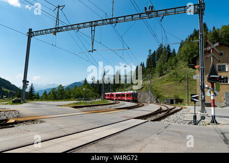 Langwies, GR / Switzerland - 24. July, 2015: the Rhaetian railway arrives at the small idyllic Langwies train station on the Chur - Arosa line Stock Photo