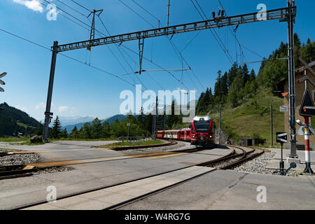 Langwies, GR / Switzerland - 24. July, 2015: the Rhaetian railway arrives at the small idyllic Langwies train station on the Chur - Arosa line Stock Photo