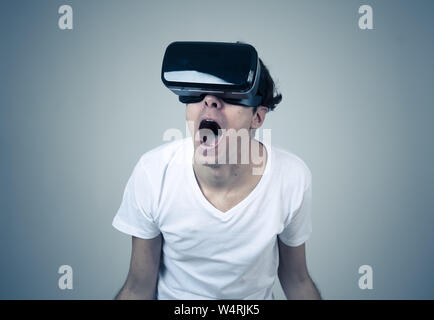 VR experience. Amazed and excited man using 360 VR headset goggles, feeling excited about simulation, making gestures having fun interacting with new Stock Photo