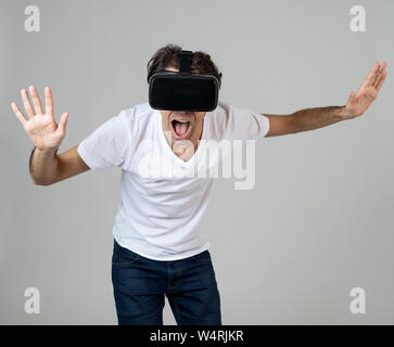 VR experience. Amazed and excited man using 360 VR headset goggles, feeling excited about simulation, making gestures having fun interacting with new Stock Photo