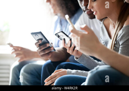 Close up young mixed race people using phones. Stock Photo