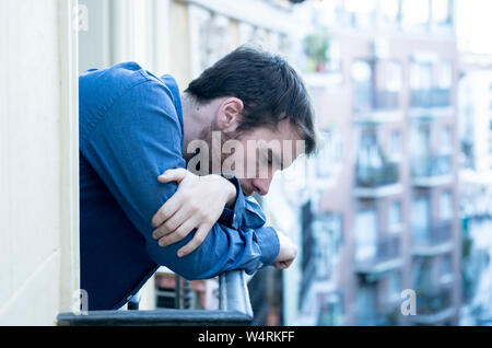 Lonely sad man staring outside house balcony feeling depressed distress and miserable. Suffering emotional crisis thinking about difficult important l Stock Photo