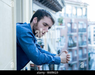 Lonely sad man staring outside house balcony feeling depressed distress and miserable. Suffering emotional crisis thinking about difficult important l Stock Photo