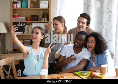 Happy young woman making selfie with diverse friends. Stock Photo
