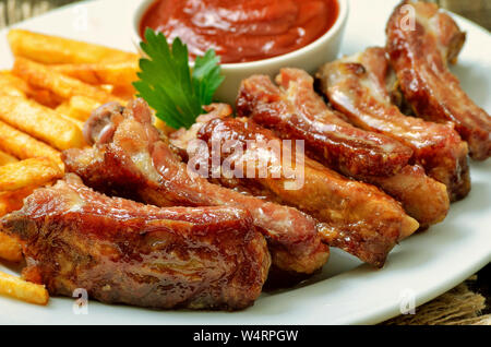 Appetizer fried pork ribs on white plate, close up view Stock Photo