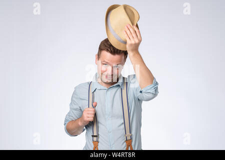 mature man waving with summer hat in studio Stock Photo