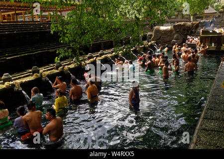 Devotees and tourists in the waters of the Tirtha Empul Templ,e or Holy Spring Water Temple, Bali, Indonesia Stock Photo