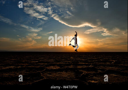 Silhouette of a man jumping in air, Dashte Kavir-Salt Desert National Park, Kashan, Iran Stock Photo