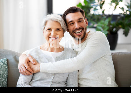 senior mother with adult son hugging at home Stock Photo