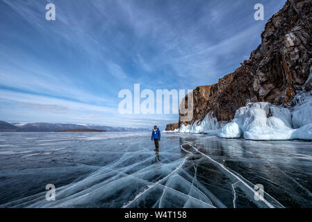 Man standing on frozen Lake Baikal in winter, Siberia, Russia Stock Photo