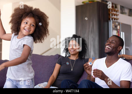 Family having fun with kid and soap bubbles at home Stock Photo