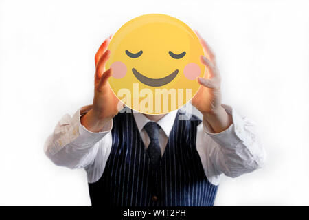 Businessman holding up a glowing smiley Stock Photo