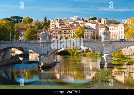 Image of Rione Ponte district. View of white Ponte Vittorio Emanuele II bridge, Vatican dome and their reflection, orange trees, waters of Tiber river Stock Photo