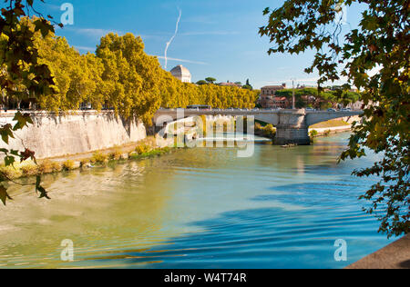 Image of Rione Ponte district. View of white Ponte Garibaldi bridge and surrounding houses, yellow trees, waters of Tiber river under blue cloudless a Stock Photo