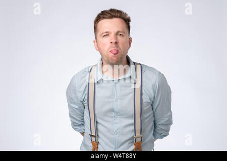 Young man shows tongue, isolated over white background Stock Photo