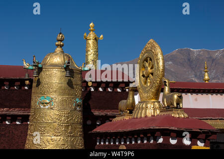 China, Tibet, Lhasa, Architectural detail of the roof of the Jokhang Buddhist temple with gilt victory banners and a dharma wheel flanked by two deer  the building  founded about 1652 AD  It is the most sacred Buddhist temple in Tibet and is a part of the Historic Ensemble of a UNESCO World Heritage Site.. Stock Photo