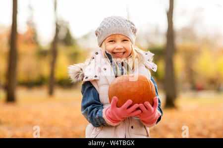happy little girl with pumpkin at autumn park Stock Photo