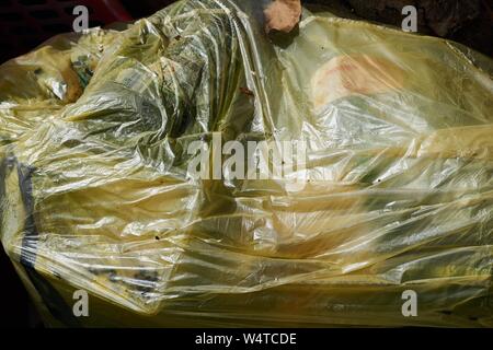 cleaning the streets in the fall, yellow garbage bags filled with fallen leaves Stock Photo