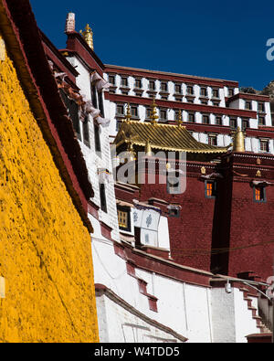 China, Tibet, Lhasa, The Ganden Monastery sits at the top of a natural amphitheater on Wangbur Mountain. It  founded in 1409 AD but was mostly destroyed in 1959 by the Chinese military  Colorfully painted architectural detail the red building is the Serdung Lhakhang. Stock Photo