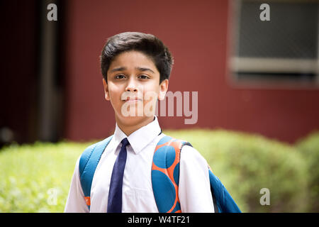 Portrait of schoolboy standing at school campus Stock Photo