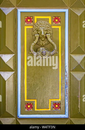 Old metal doorknob in the shape of lion head on old wooden door Stock Photo