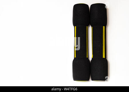 Two black dumbbells with a soft coating on a white background Stock Photo