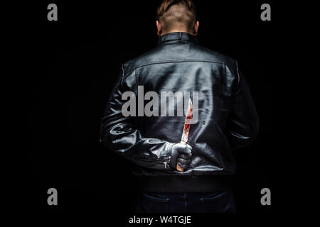 Serial killer maniac holding killer tools behind his back Stock Photo