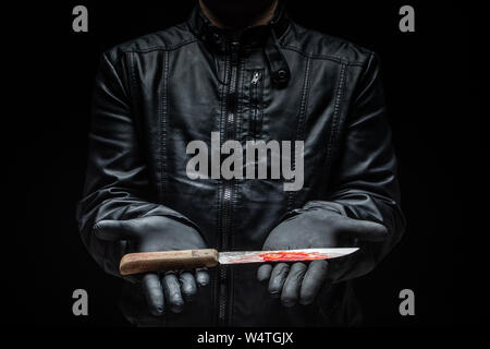 Serial killer maniac holding knife on his hands with gloves / killer tools Stock Photo