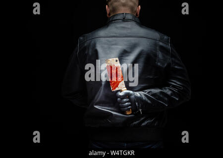 Serial killer maniac holding killer tools behind his back Stock Photo