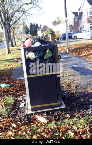 Overflowing dog waste bin on leafy street in Leamington Spa, Warwickshire, England Stock Photo