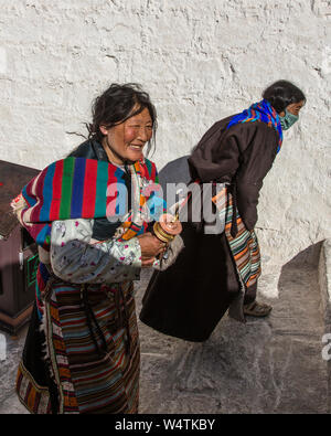 China, Tibet, Lhasa, Two Khamba Tibetan women from the Kham region of eastern Tibet on a pilgrimage to visit holy sites  they are wearing their colorful traditional bangdian or pangden aprons. Stock Photo