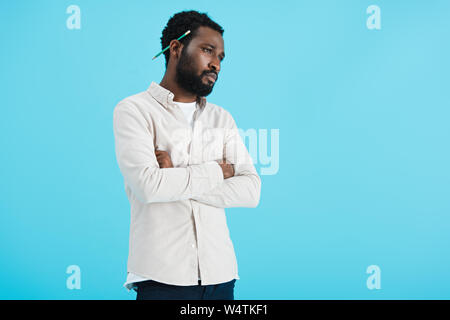 pensive african american man with pencil isolated on blue Stock Photo