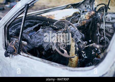 Problem on road. Car after accident with fire. Close-up of burnt vehicle steering wheel. Stock Photo