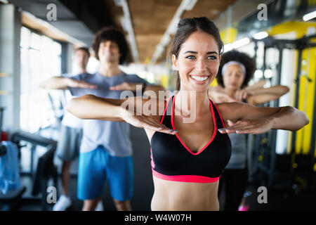 Happy gorup of healthy people training in gym Stock Photo