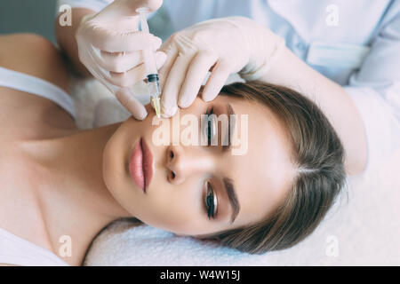 beauty injections into beautiful face. smoothing of mimic wrinkles , cosmetologist making biorevitalization Stock Photo