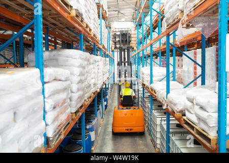 Male worker driving forklift in warehouse Stock Photo