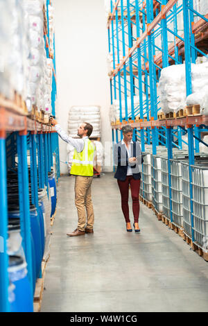 Male worker scanning package with barcode scanner in modern warehouse Stock Photo