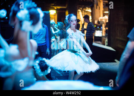 Ballet dancer in the wings in white tutu, stretching her arms Stock Photo
