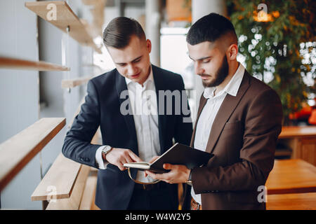 Two businessmen working in a cafe Stock Photo