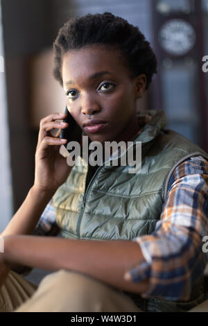 Female worker talking on mobile phone in warehouse Stock Photo