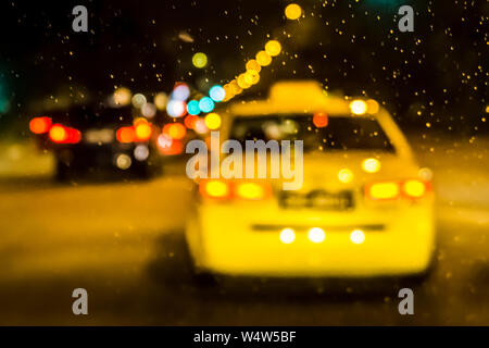 Yellow Taxi in Singapore street, on the way back home - Bokeh and blurry effect, Stock Photo