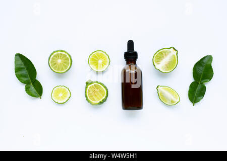 Bottle of essential oil with fresh kaffir lime or bergamot fruit isolated on white Stock Photo