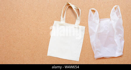 White fabric bag with white plastic bag on plywood background.  Copy space Stock Photo