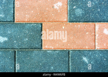 Fragment of a sidewalk lined with multicolored stone tiles for use as an abstract background and texture. Stock Photo