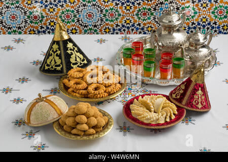 Traditional Moroccan homemade cookies in festive metal tajines on an embroidered tablecloth Stock Photo